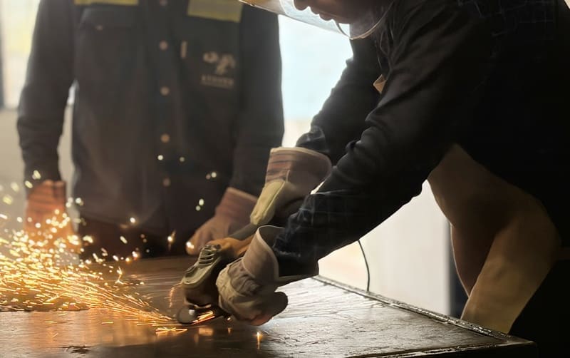 Joven con casco de seguridad realizando trabajos de soldadura