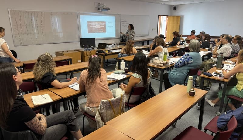 Karin Arbach en el salón de clases exponiendo diapositivas a los participantes