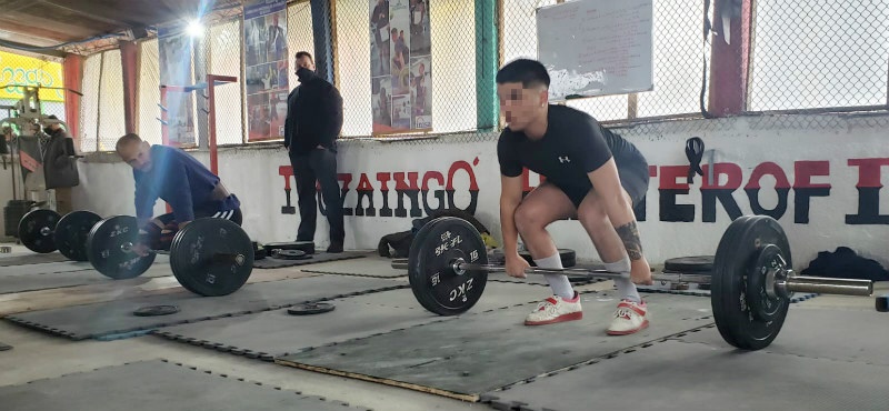 joven levantando pesas en el gimnasio